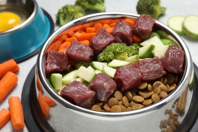 Photo of Dry pet food and natural products on light table, closeup