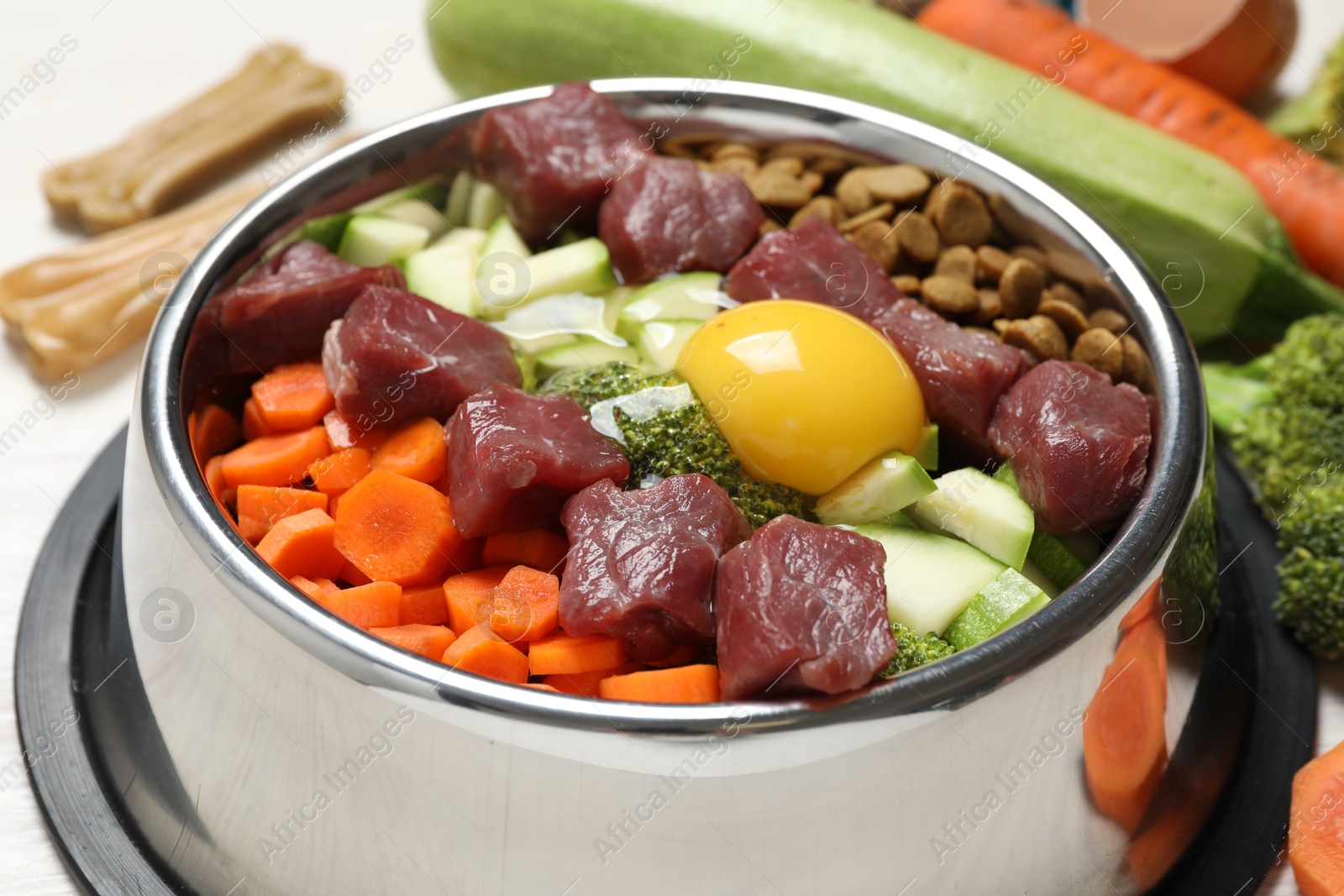 Photo of Dry pet food and natural products on white table, closeup