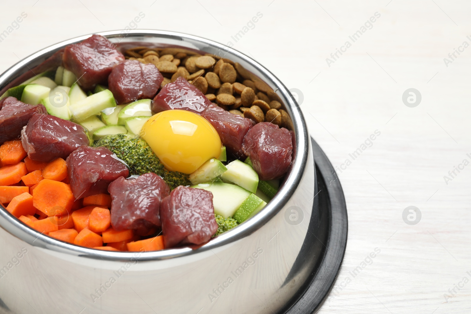 Photo of Dry pet food and natural products on white wooden table, closeup