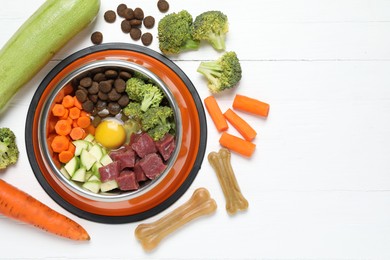 Photo of Dry pet food and natural products on white table, top view