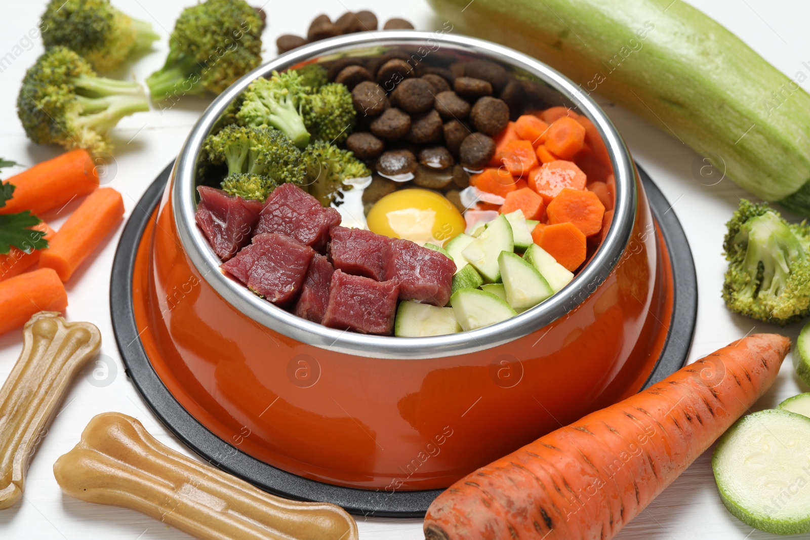 Photo of Dry pet food and natural products on white wooden table, closeup