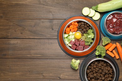 Photo of Dry pet food and natural products on wooden table, top view. Space for text