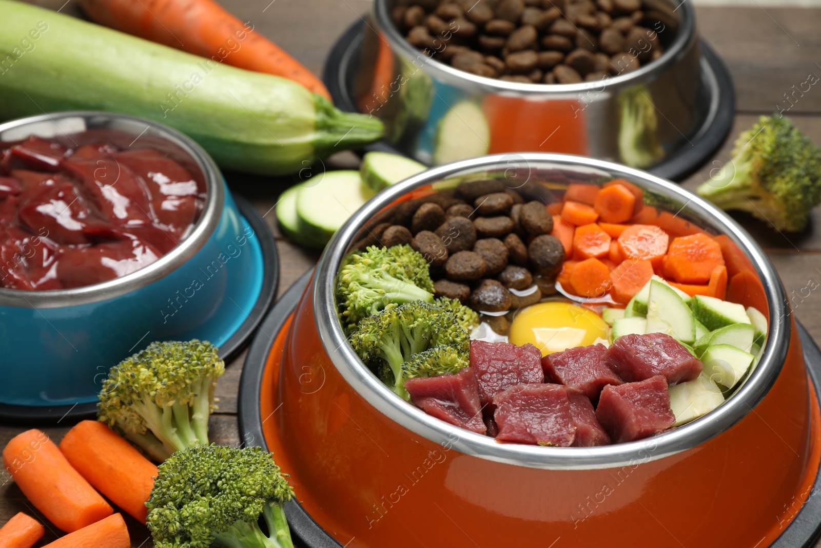 Photo of Dry pet food and natural products on wooden table, closeup