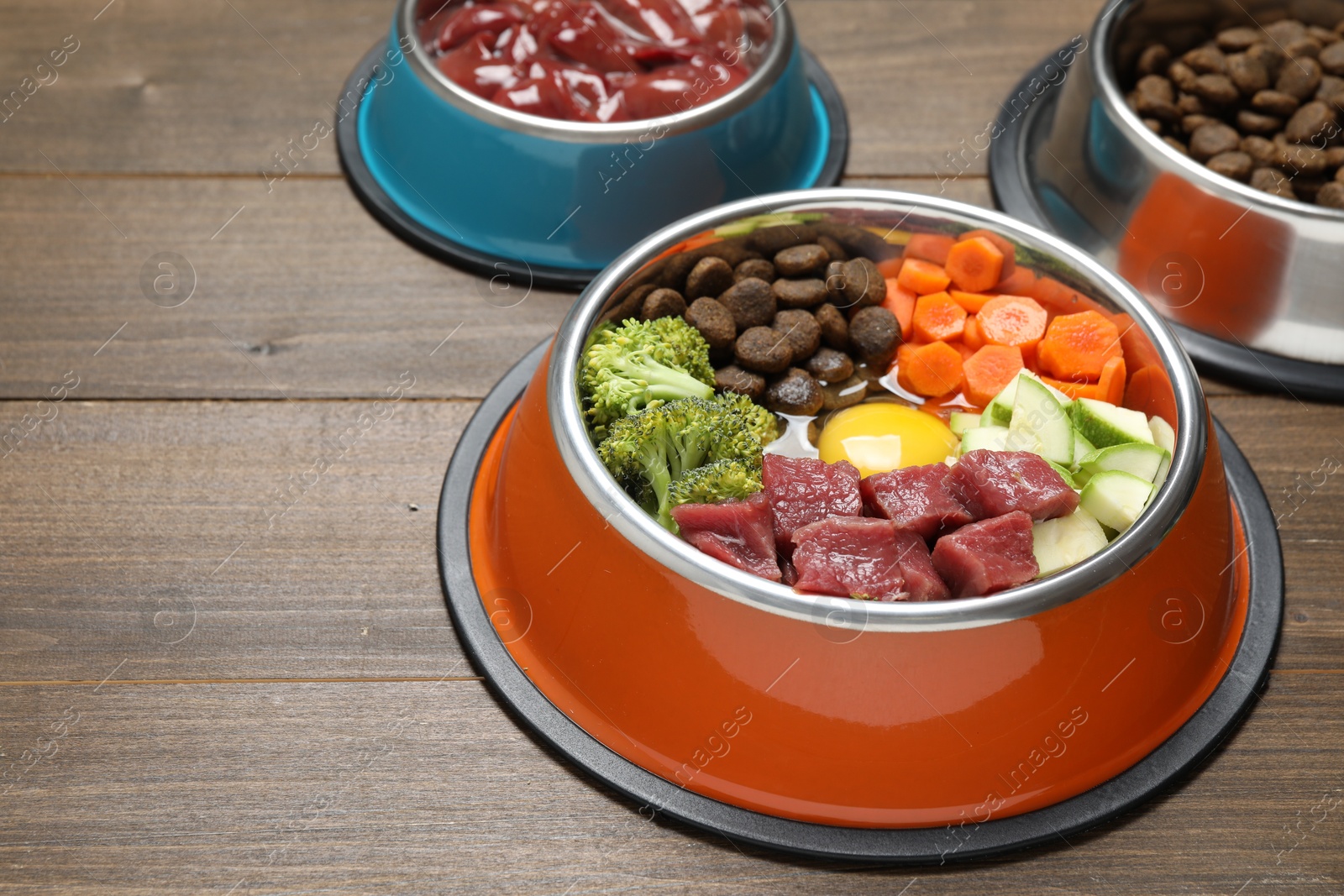 Photo of Dry pet food and natural products on wooden table, closeup