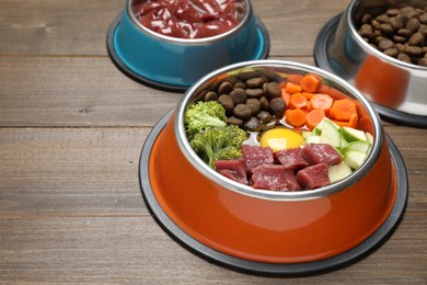 Photo of Dry pet food and natural products on wooden table, closeup