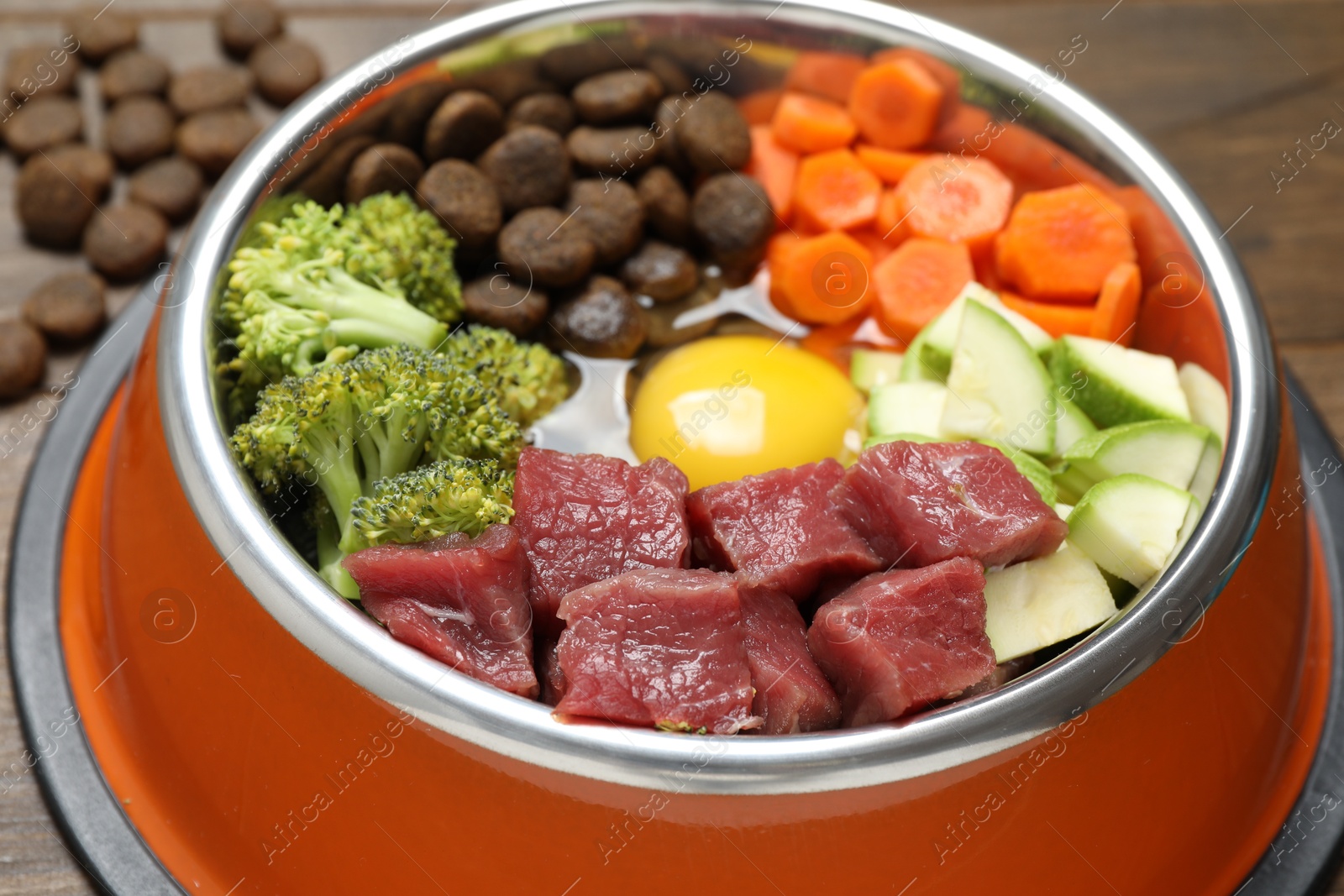 Photo of Dry pet food and natural products on wooden table, closeup