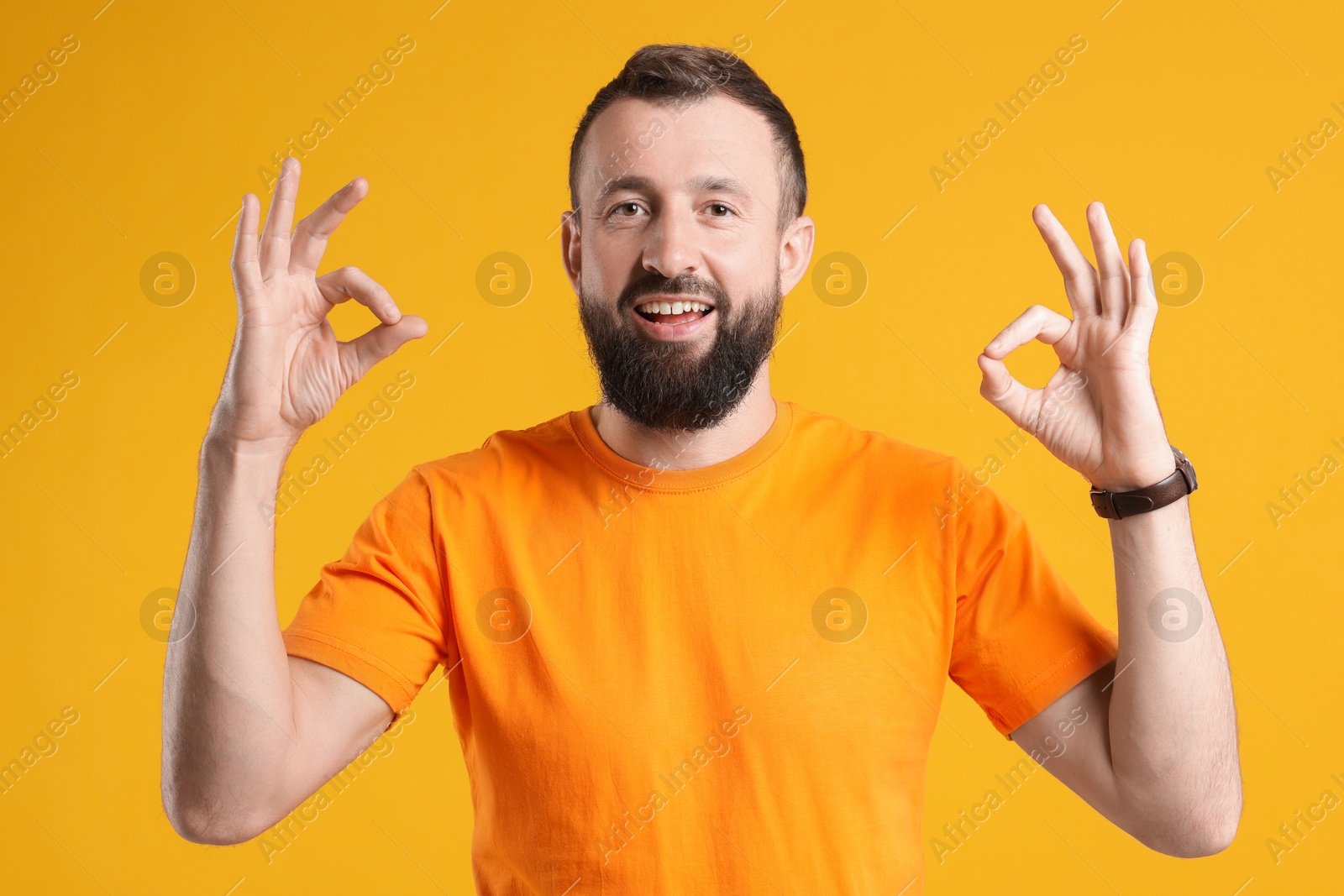 Photo of Happy man showing okay gesture on orange background