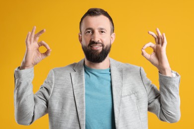 Photo of Man showing okay gesture on orange background