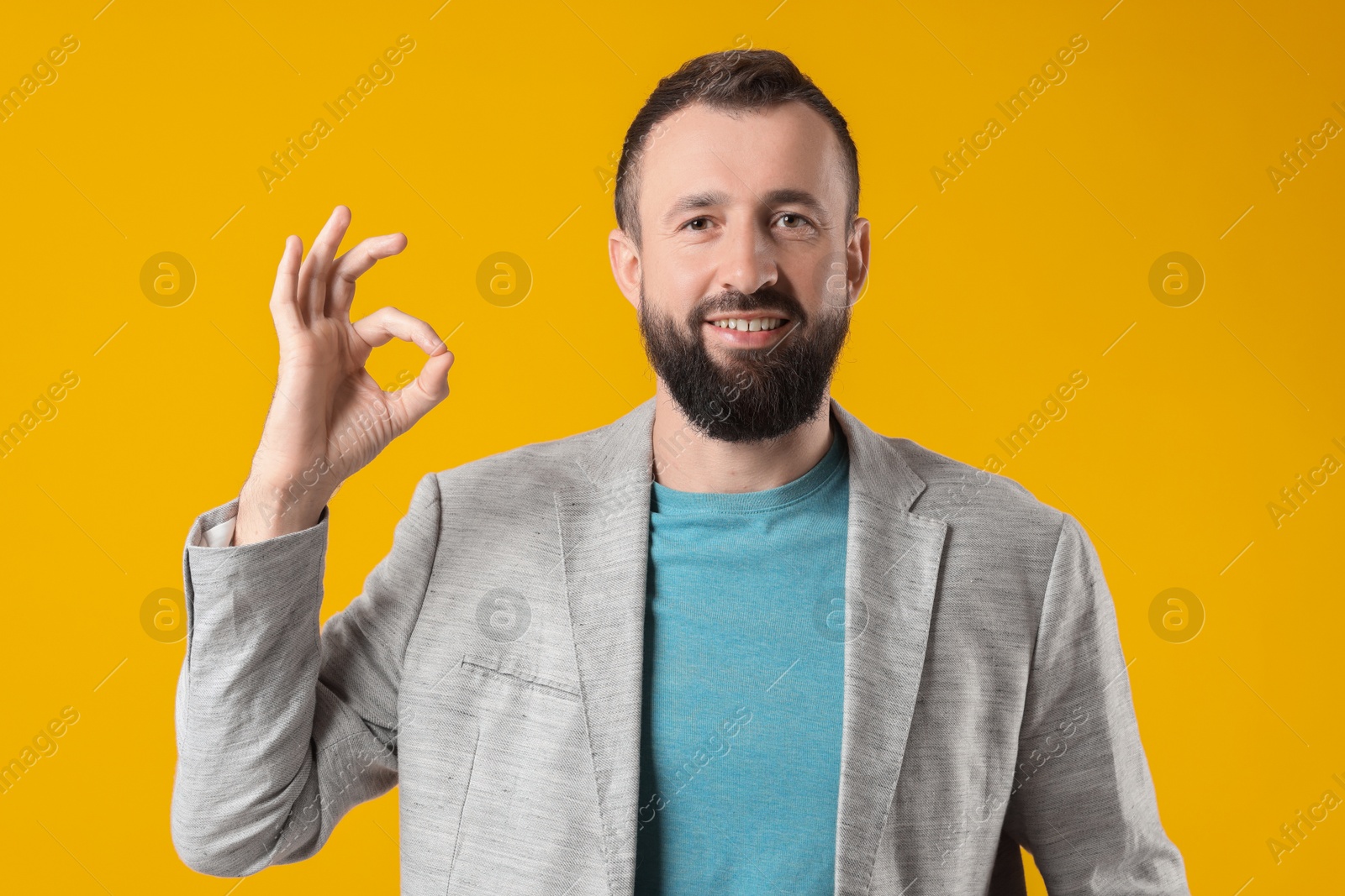 Photo of Man showing okay gesture on orange background