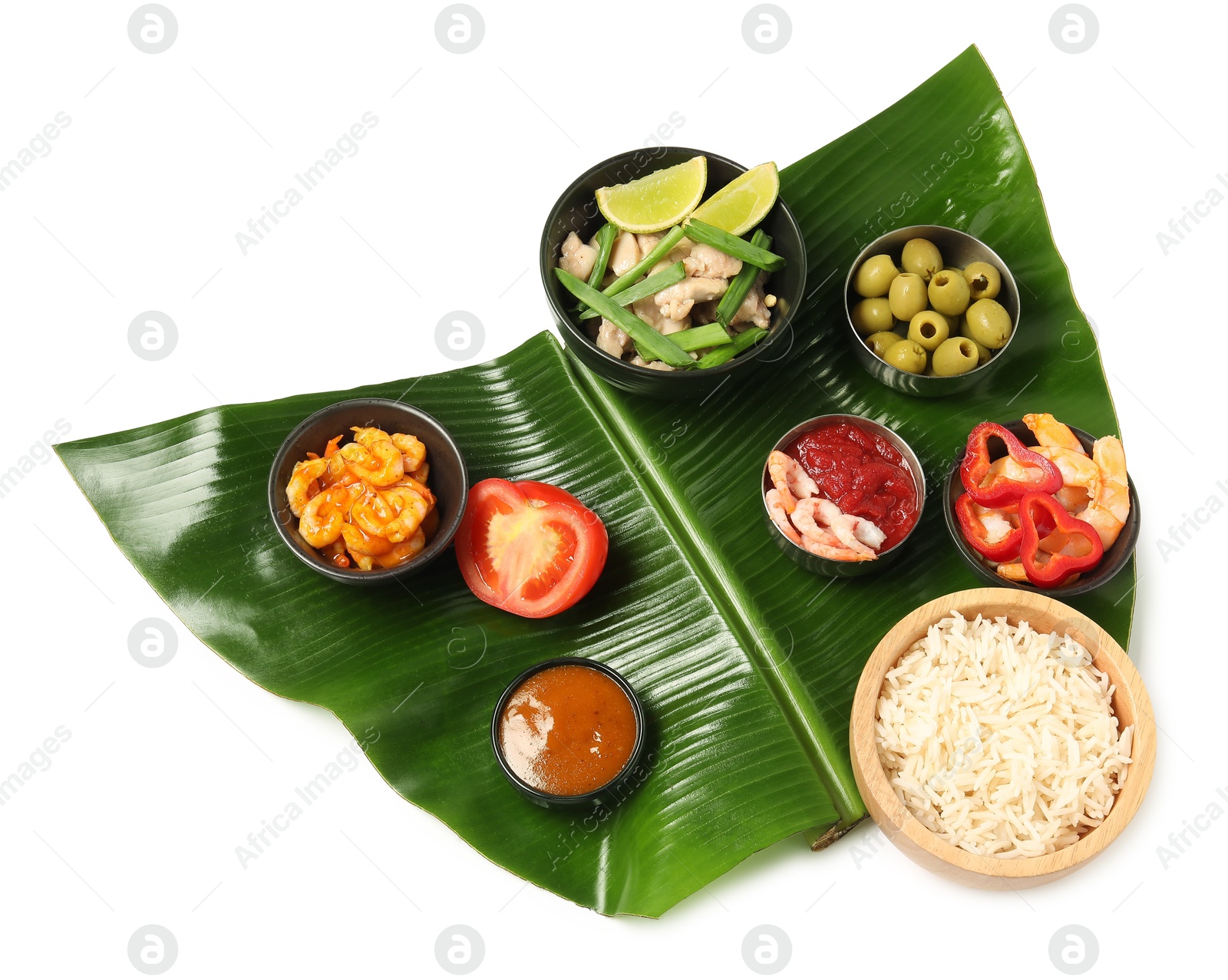 Photo of Cut banana leaf with different food and sauce isolated on white, top view. Healthy eco serving