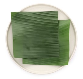 Photo of Pieces of banana leaves isolated on white, top view. Traditional meal serving