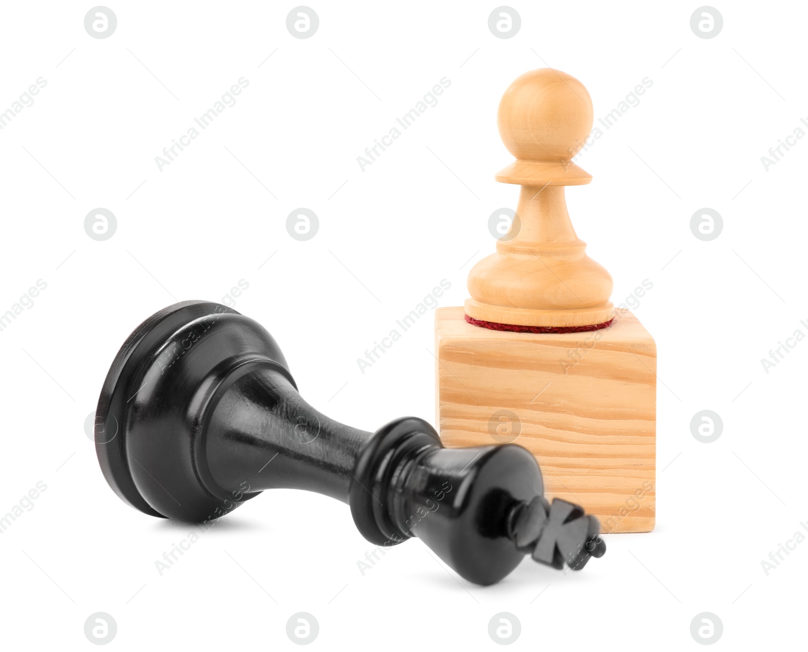 Photo of Pawn on wooden block near fallen king chess against white background. Competition concept