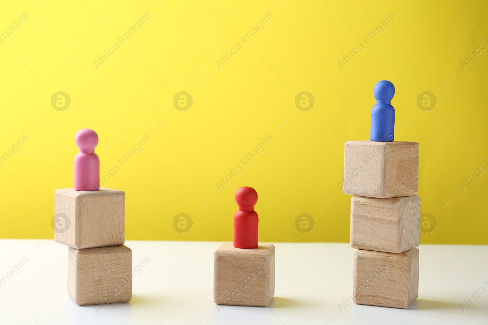 Photo of Competition concept. Human figures on wooden cubes against color background, space for text