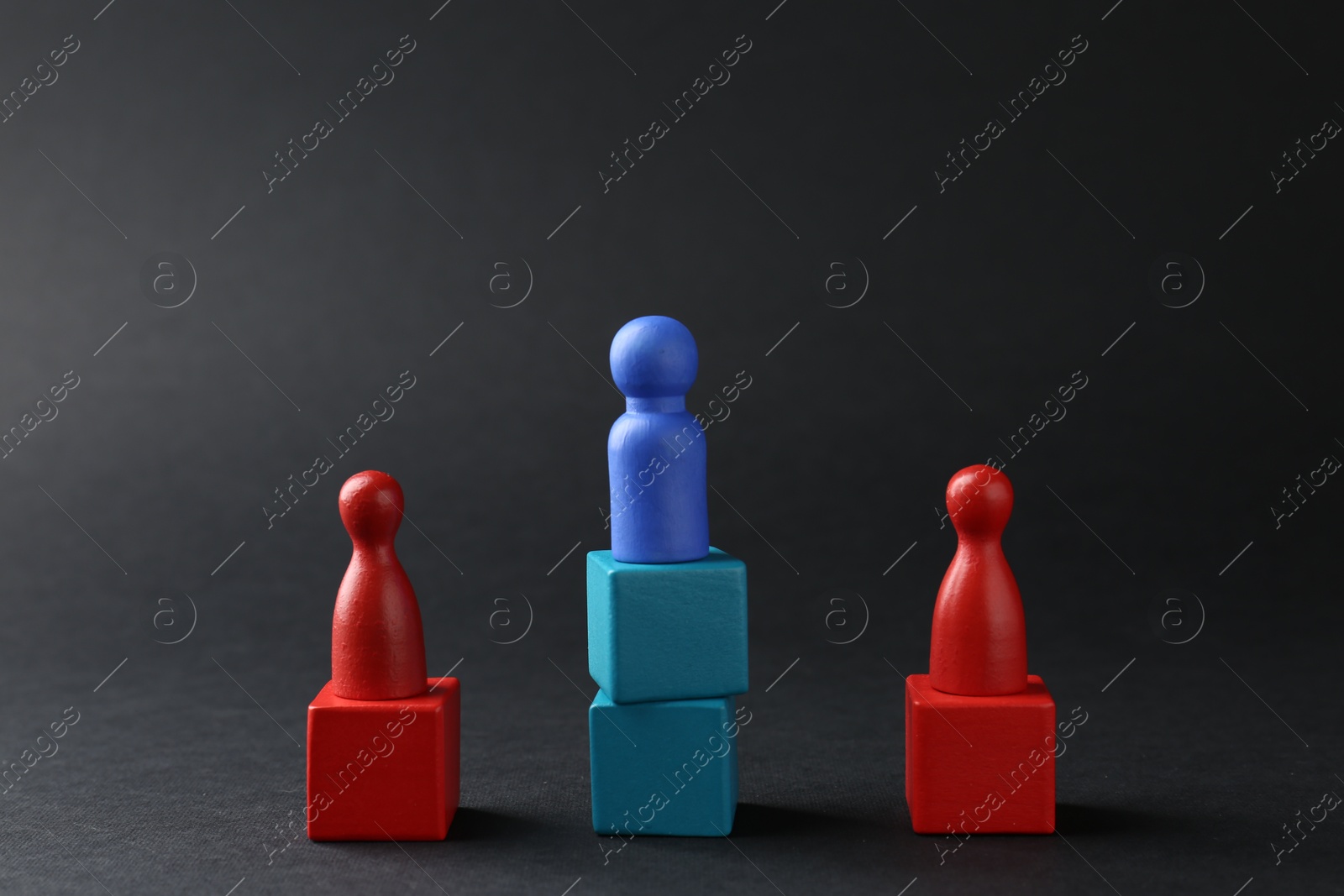 Photo of Competition concept. Human figures on wooden cubes against black background