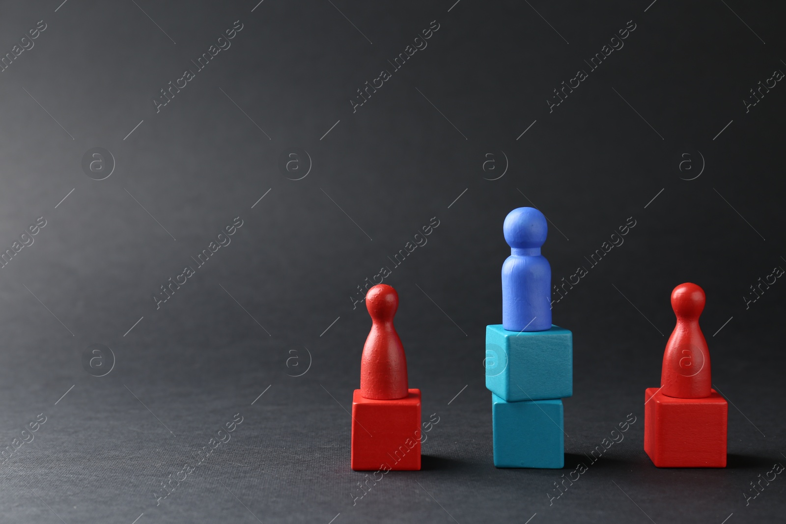 Photo of Competition concept. Human figures on wooden cubes against black background, space for text