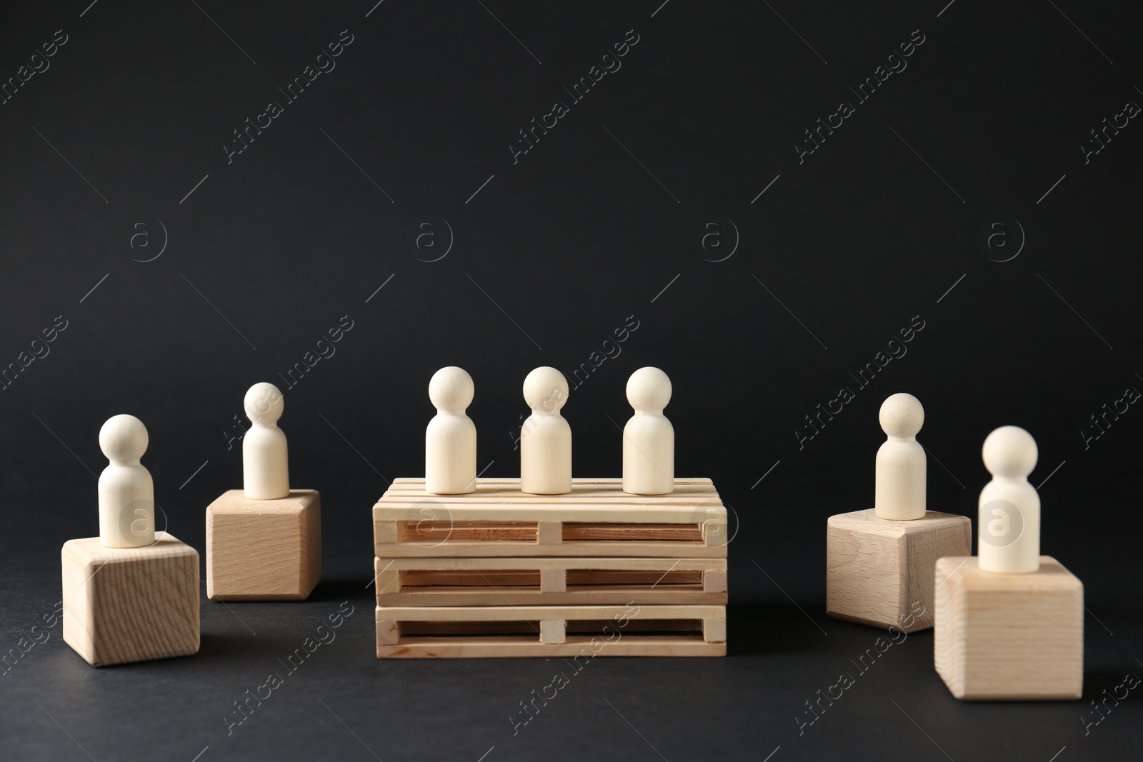 Photo of Competition concept. Human figures on different podiums against black background