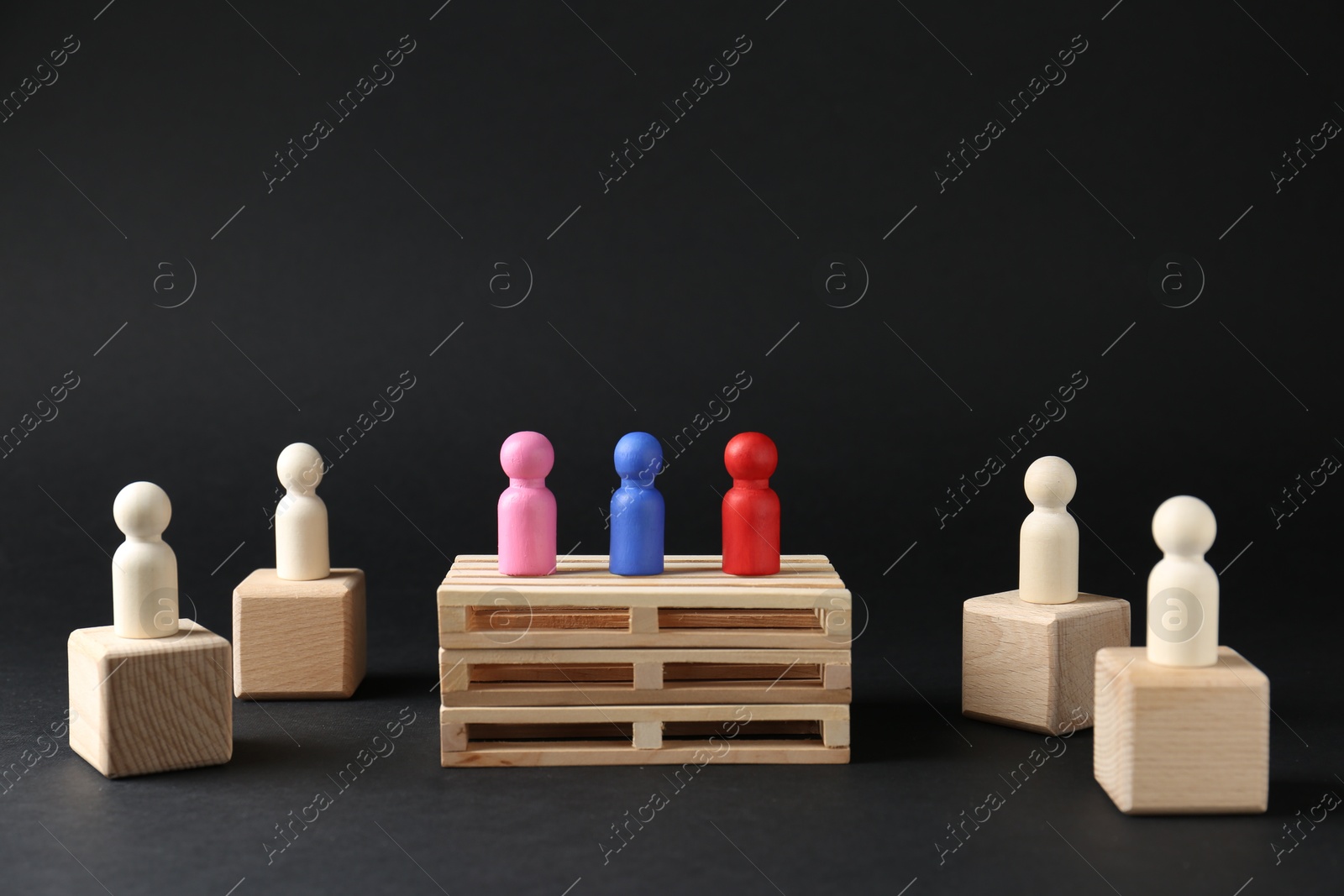 Photo of Competition concept. Human figures on different podiums against black background