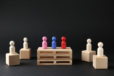 Photo of Competition concept. Human figures on different podiums against black background