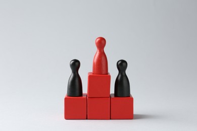 Photo of Competition concept. Human figures on wooden cubes against light background