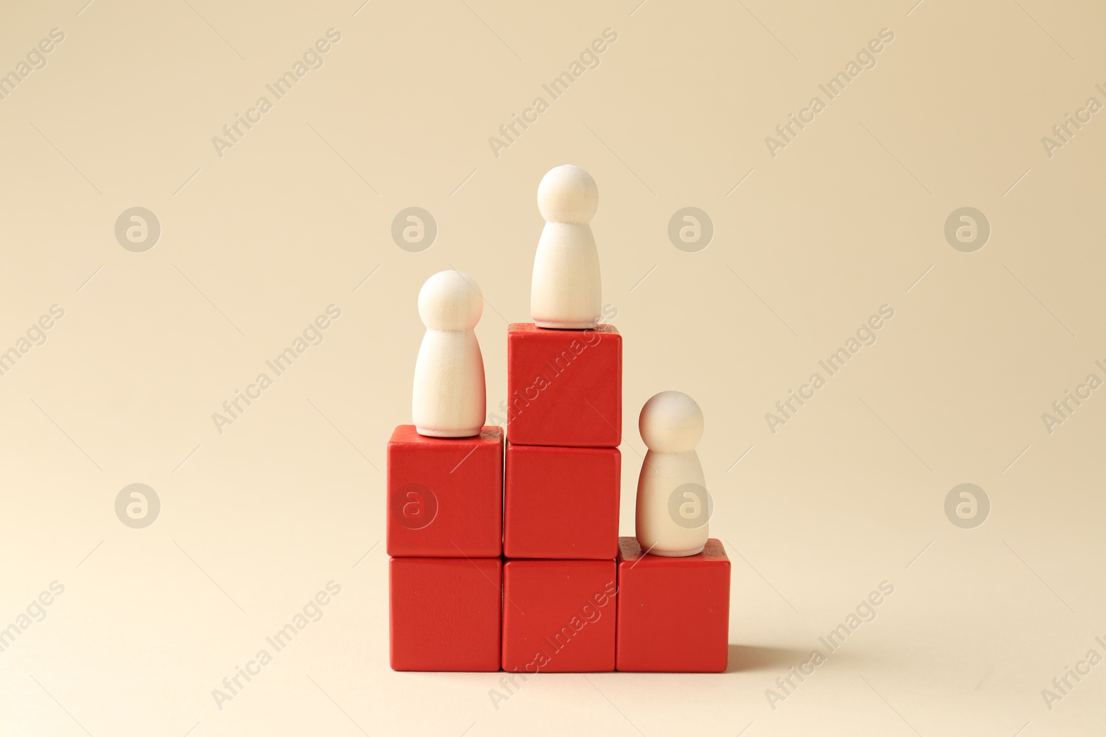 Photo of Competition concept. Human figures on wooden cubes against beige background