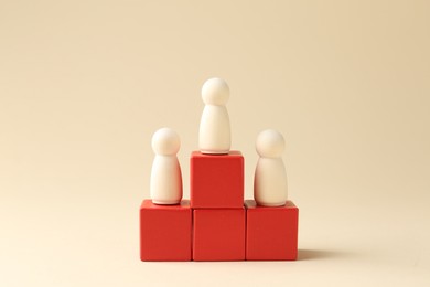 Competition concept. Human figures on wooden cubes against beige background