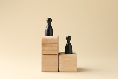 Photo of Competition concept. Human figures on wooden cubes against beige background