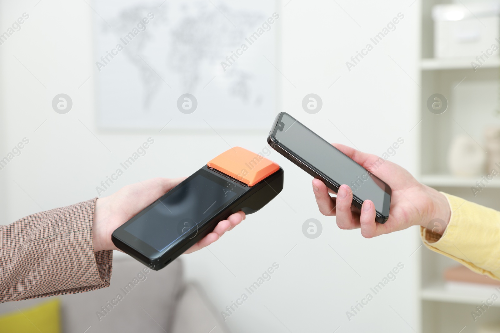 Photo of Woman paying for service with smartphone via terminal indoors, closeup