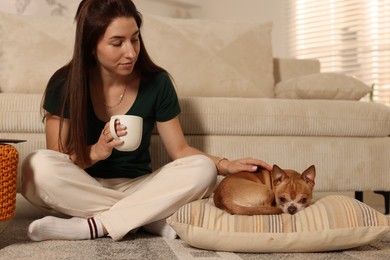 Photo of Young woman with her cute dog at home