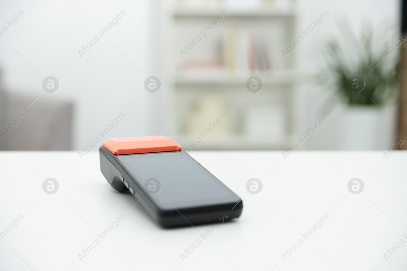 Photo of Payment terminal on white table indoors, closeup. Space for text