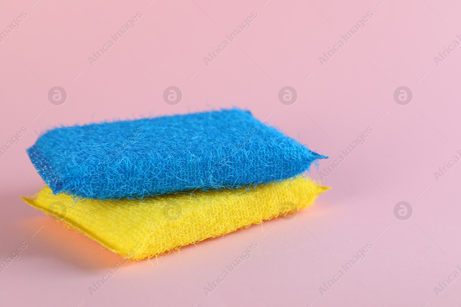 Photo of Colorful sponges on pink background, closeup. Space for text