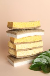 Photo of Stack of different sponges on beige background, closeup