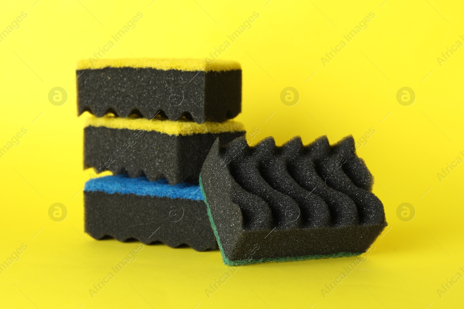 Photo of Different clean sponges on yellow background, closeup