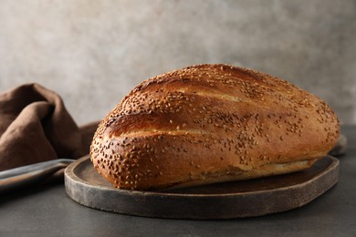 Photo of Freshly baked bread with seeds on grey table, closeup