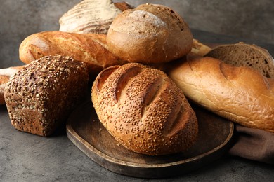 Different freshly baked bread loafs on grey table, closeup