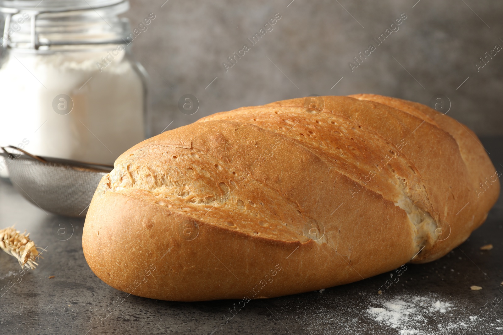 Photo of Freshly baked bread on grey table, closeup