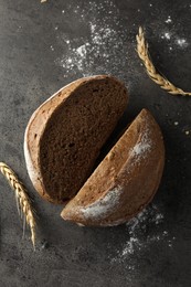 Photo of Halves of fresh bread and spikes on grey table, flat lay