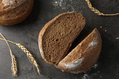 Photo of Freshly baked bread and spikes on grey table, flat lay