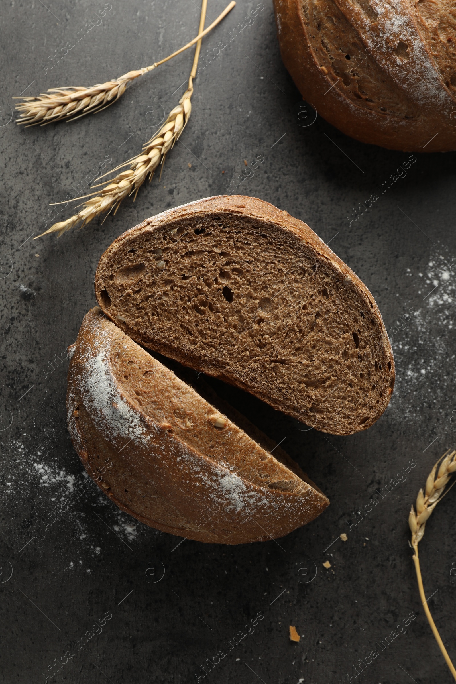 Photo of Freshly baked bread and spikes on grey table, flat lay