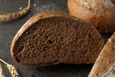 Photo of Freshly baked bread and spikes on grey table, closeup