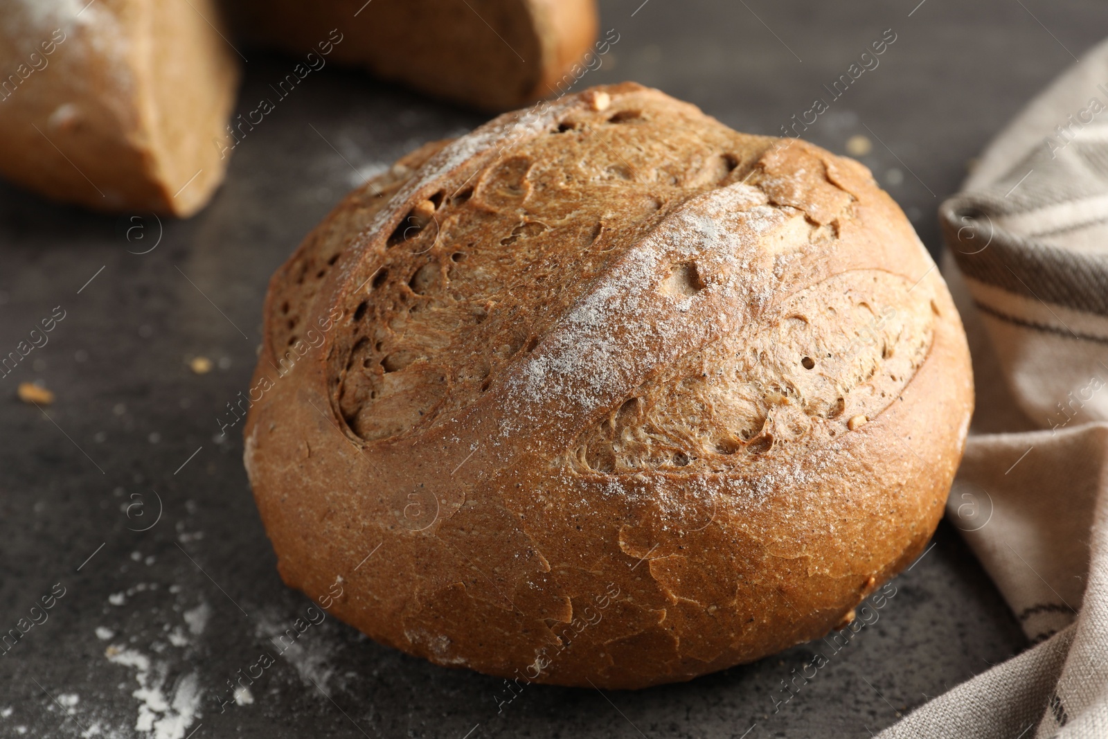 Photo of Freshly baked bread on grey table, closeup