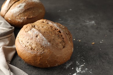 Freshly baked bread loafs on grey table, closeup. Space for text