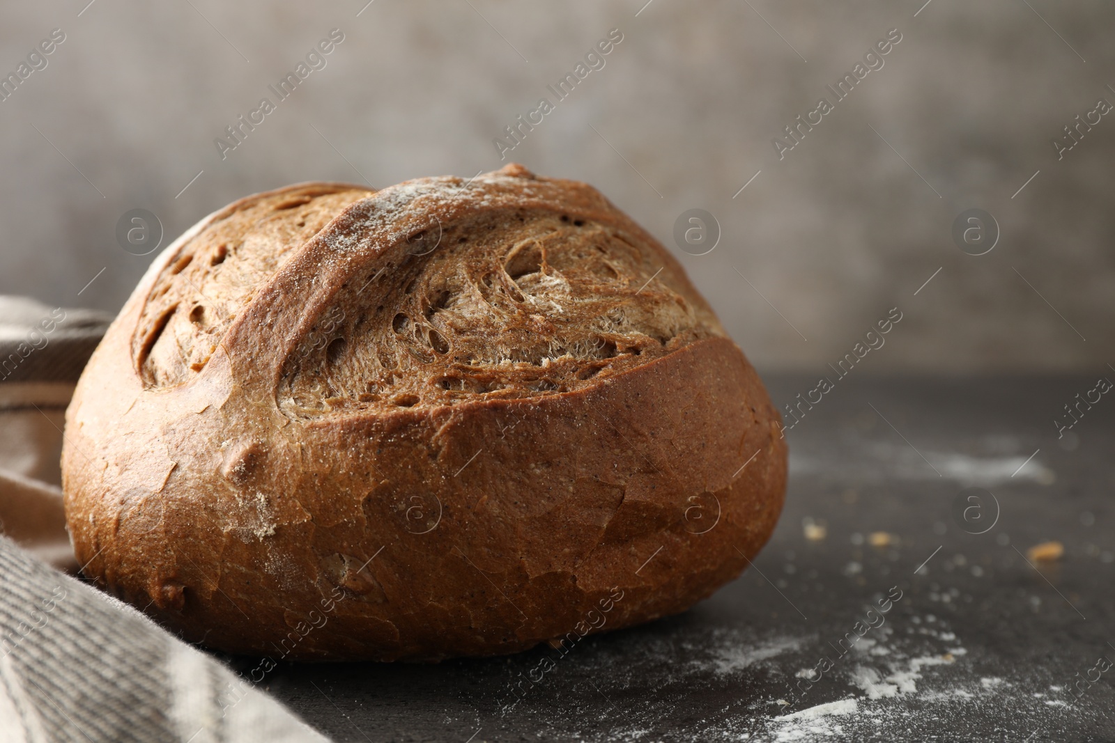 Photo of Freshly baked bread on grey table, closeup. Space for text