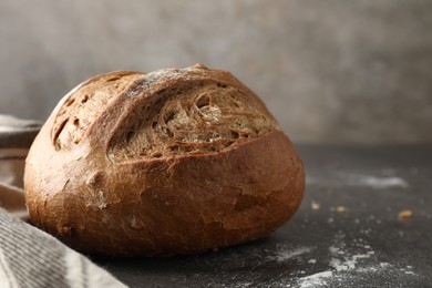 Photo of Freshly baked bread on grey table, closeup. Space for text