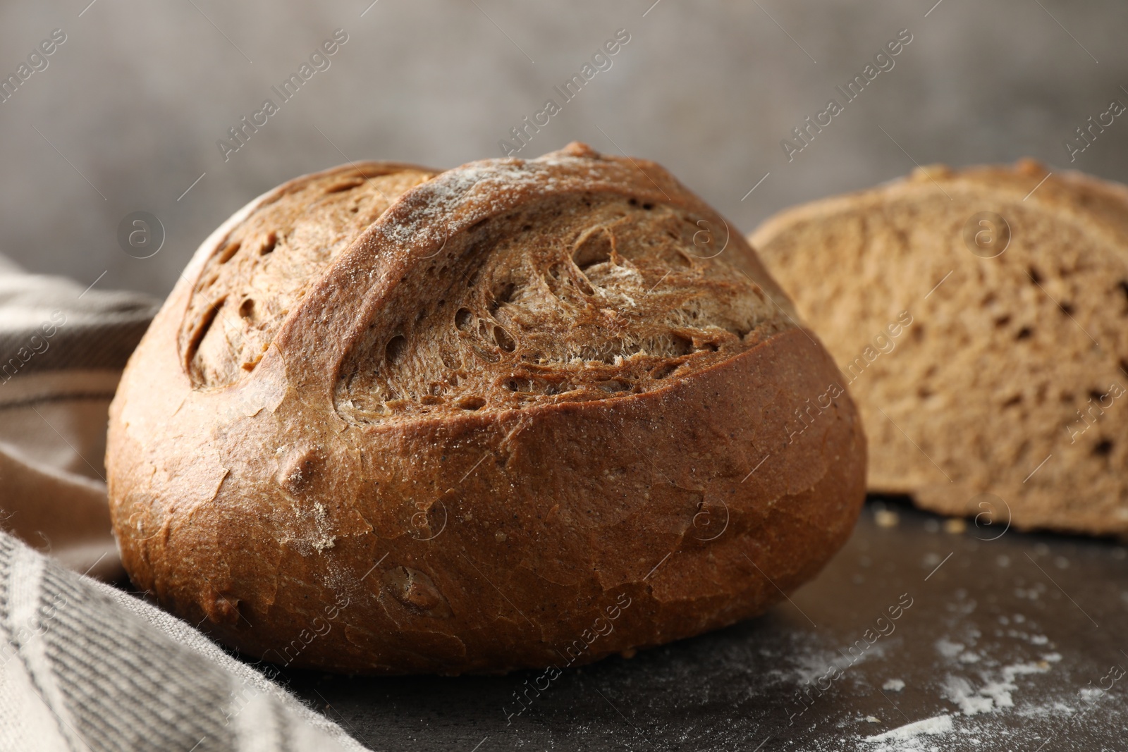 Photo of Freshly baked bread on grey table, closeup