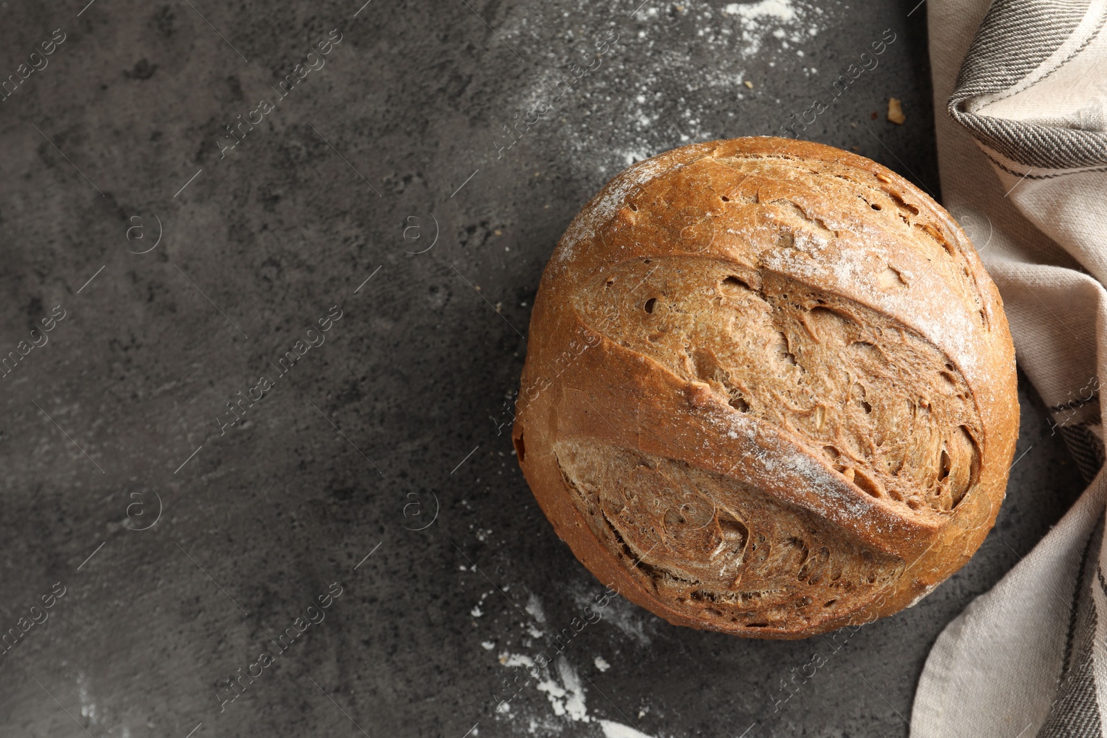 Photo of Freshly baked bread on grey table, top view. Space for text