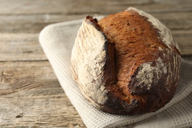 Photo of Freshly baked bread on wooden table, closeup. Space for text