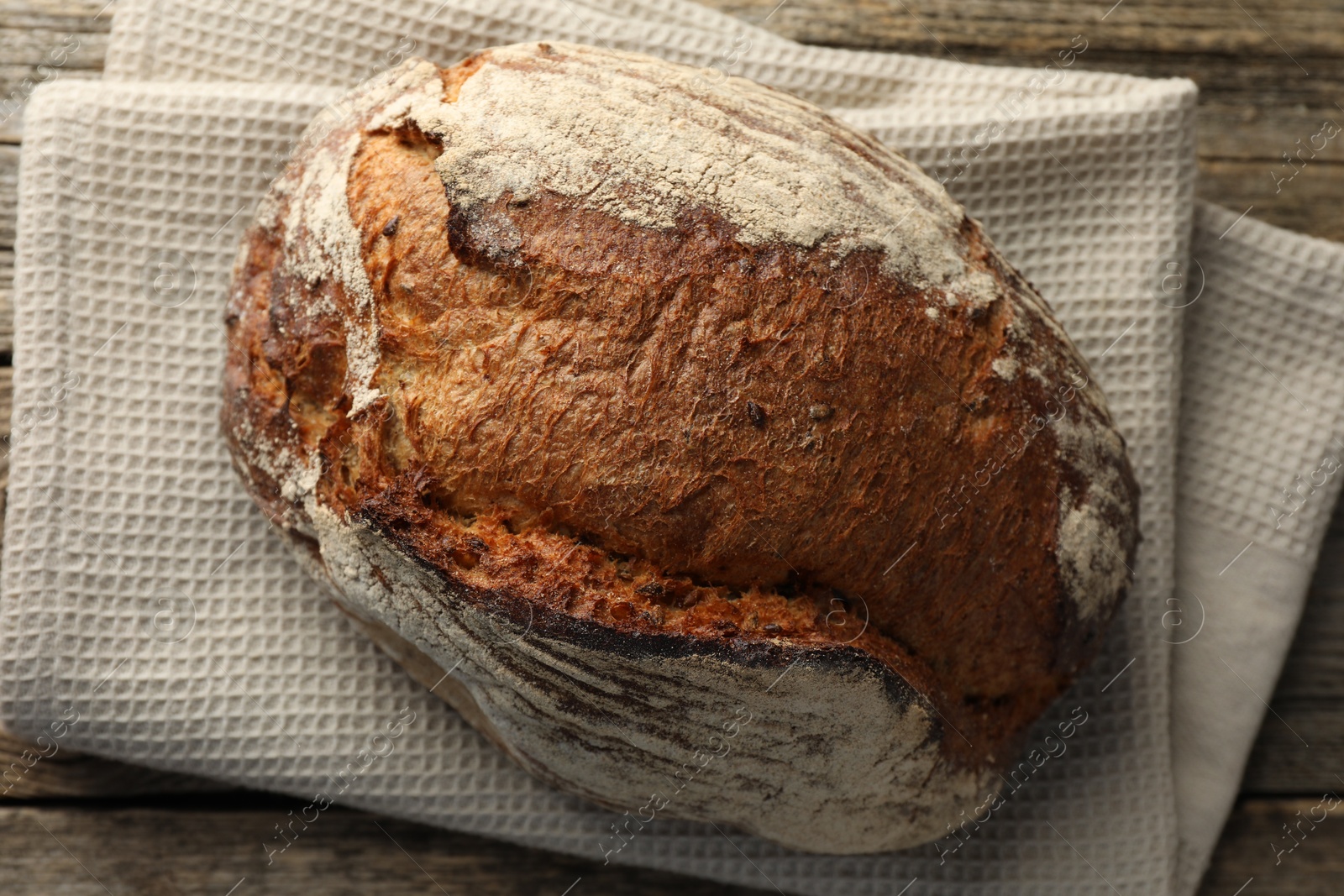 Photo of Freshly baked bread on wooden table, top view