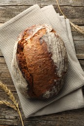 Photo of Freshly baked bread and spikes on wooden table, top view