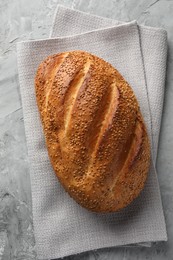 Photo of Freshly baked bread with seeds on grey table, top view