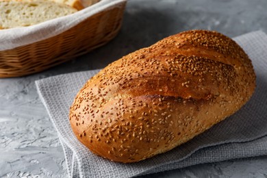 Photo of Freshly baked bread with seeds on grey table, closeup